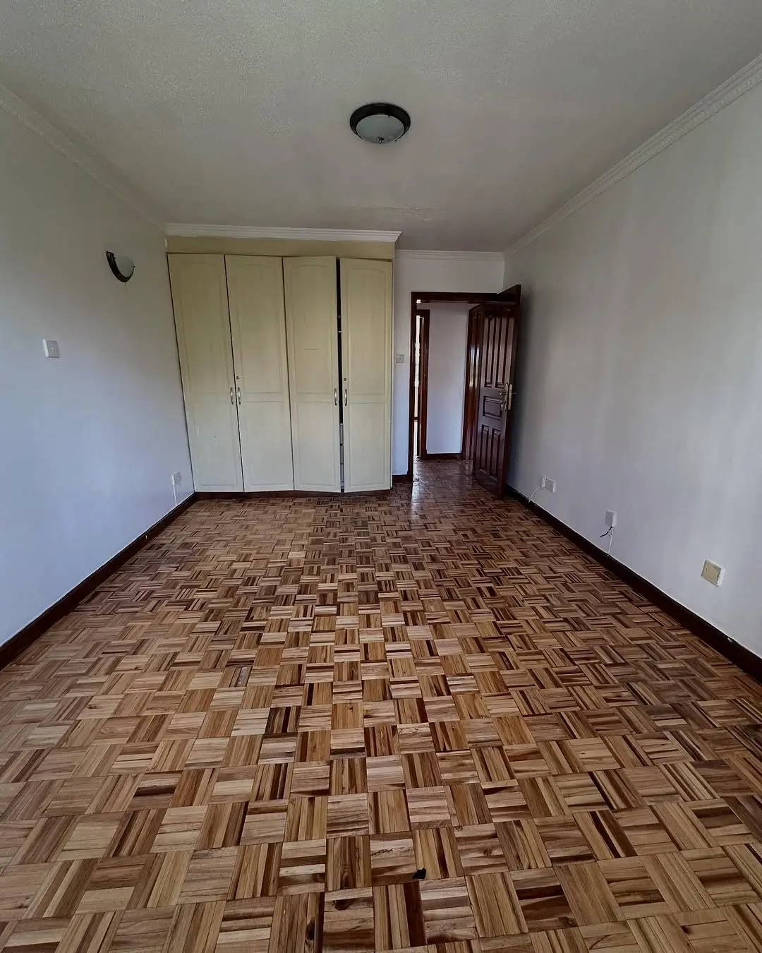 Spacious bedroom with built-in wardrobes and parquet flooring