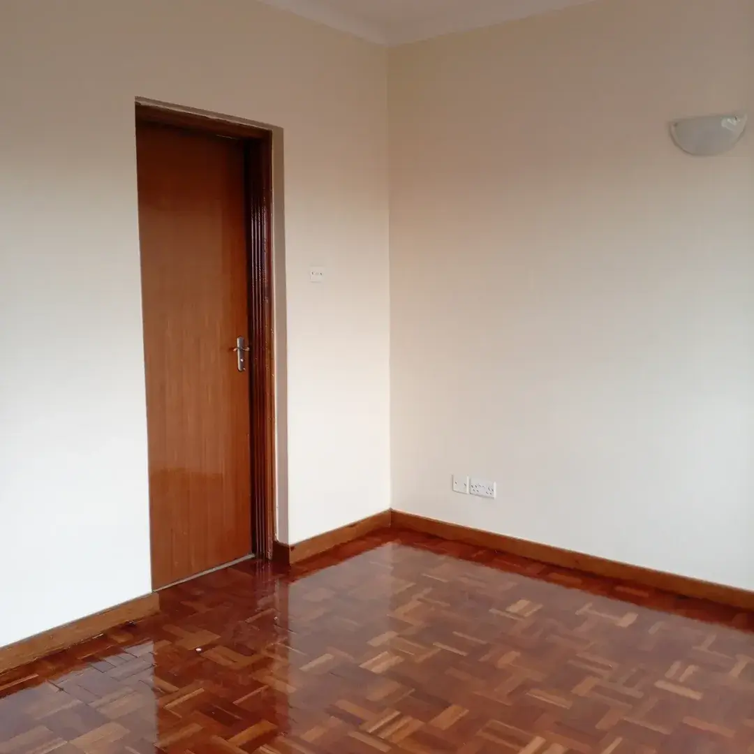Empty bedroom with wooden door and parquet flooring