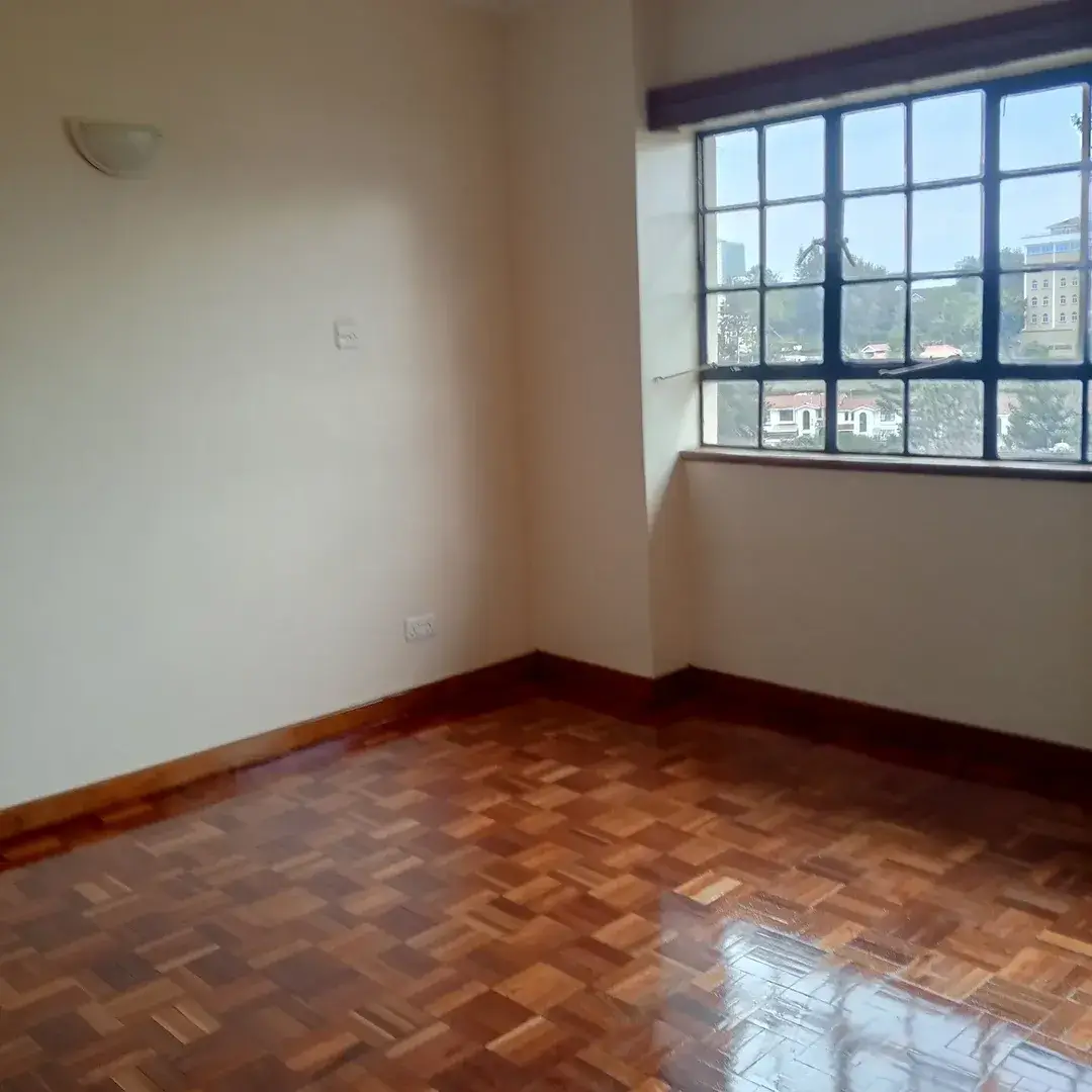 Spacious bedroom with herringbone floor and city views