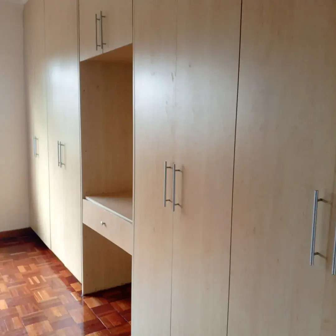 Bedroom with built-in wardrobes and terracotta tile flooring