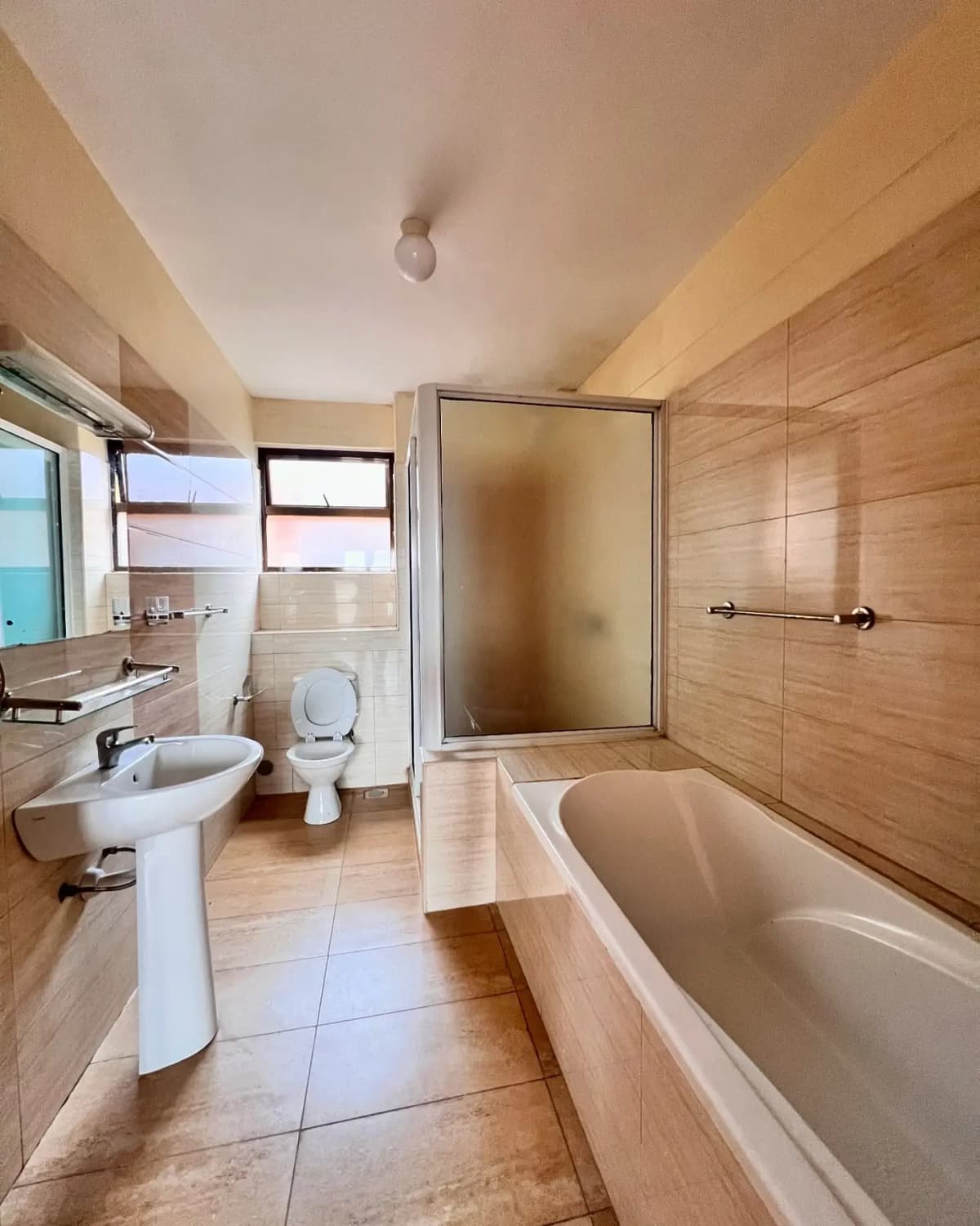 Spacious bathroom with bathtub, sink, toilet, and shower enclosure