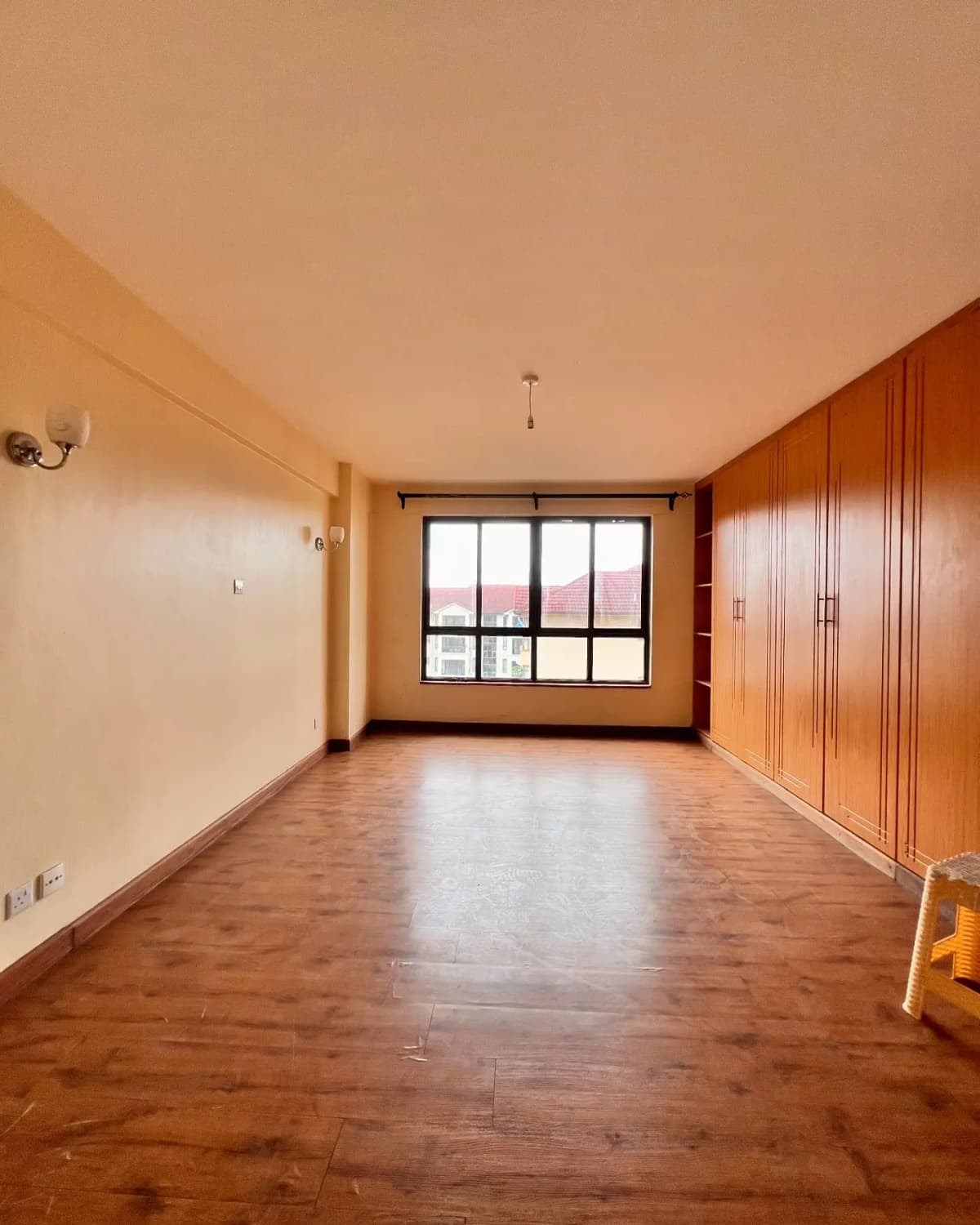 Spacious bedroom with wooden flooring and built-in wardrobes