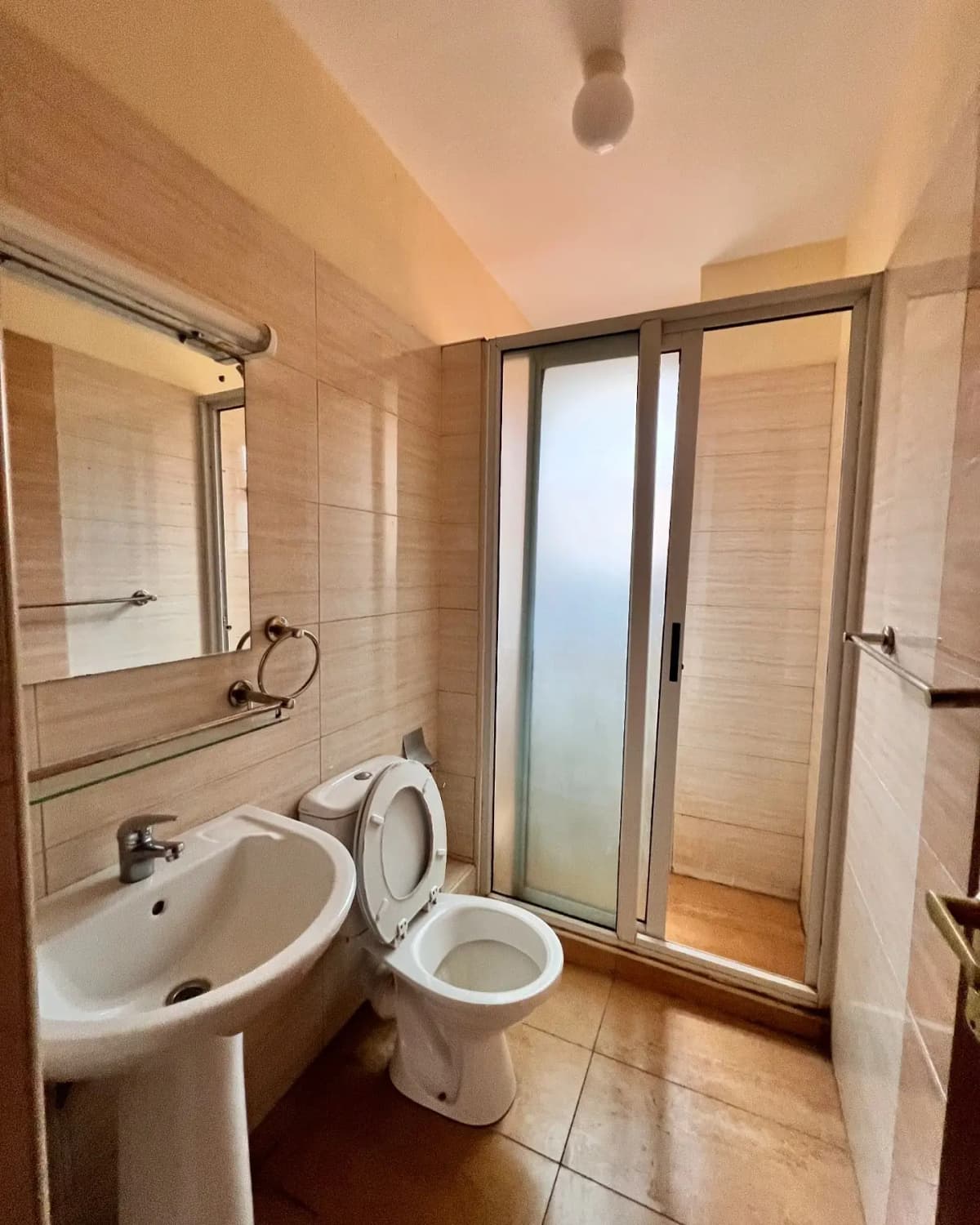 Compact bathroom with pedestal sink and toilet