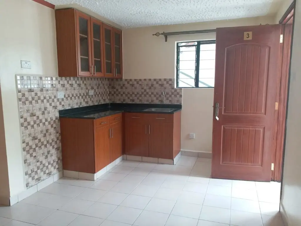 Compact kitchen with wooden cabinetry and tiled backsplash