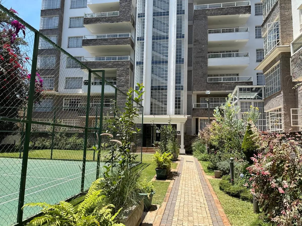 Landscaped compound grounds with tennis court and flowering plants