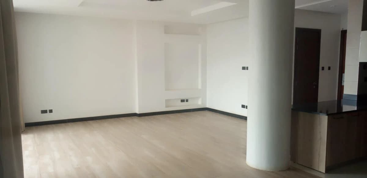 Spacious open-plan living area with support column, unfinished
