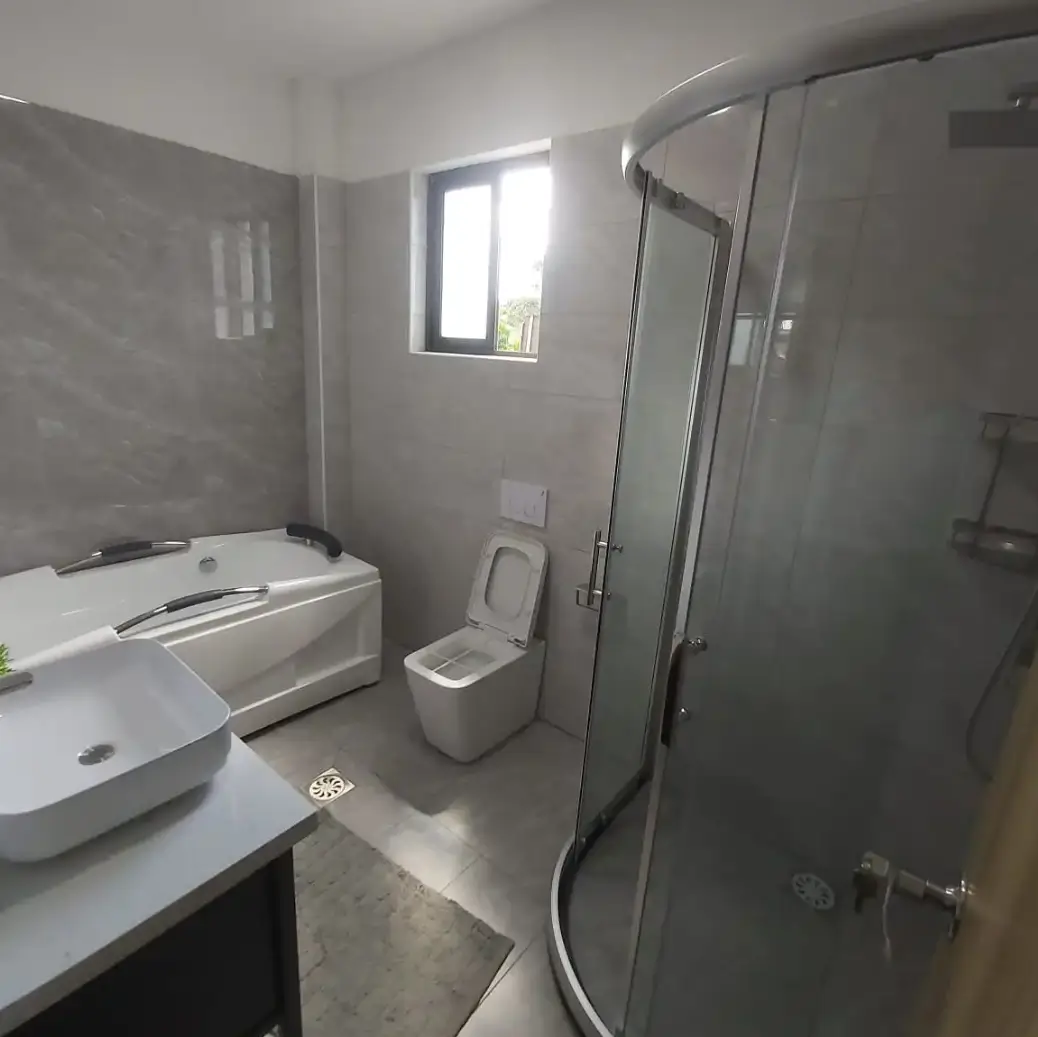 Modern bathroom with curved shower enclosure and white fixtures