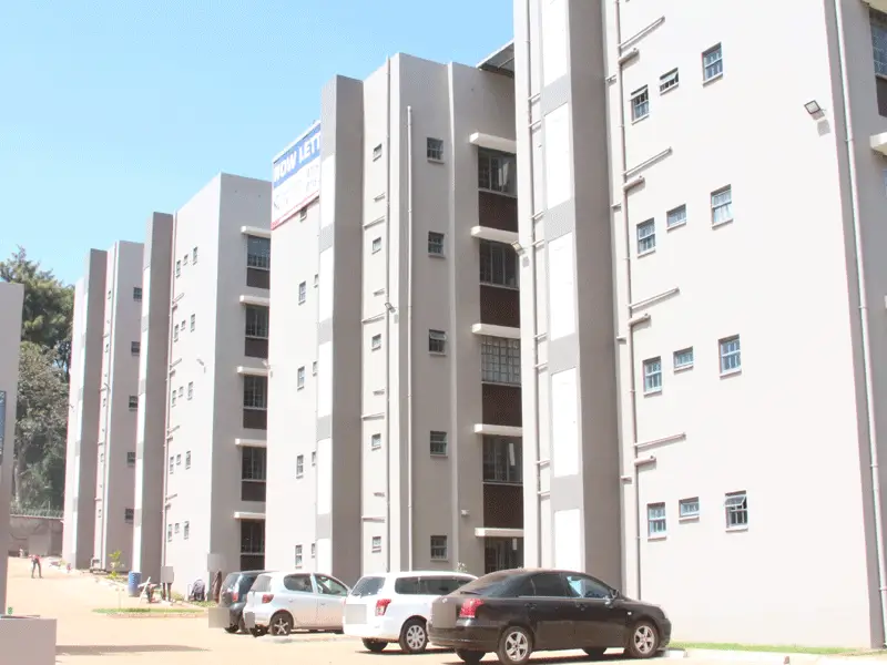 Multi-story residential building facade with parking area