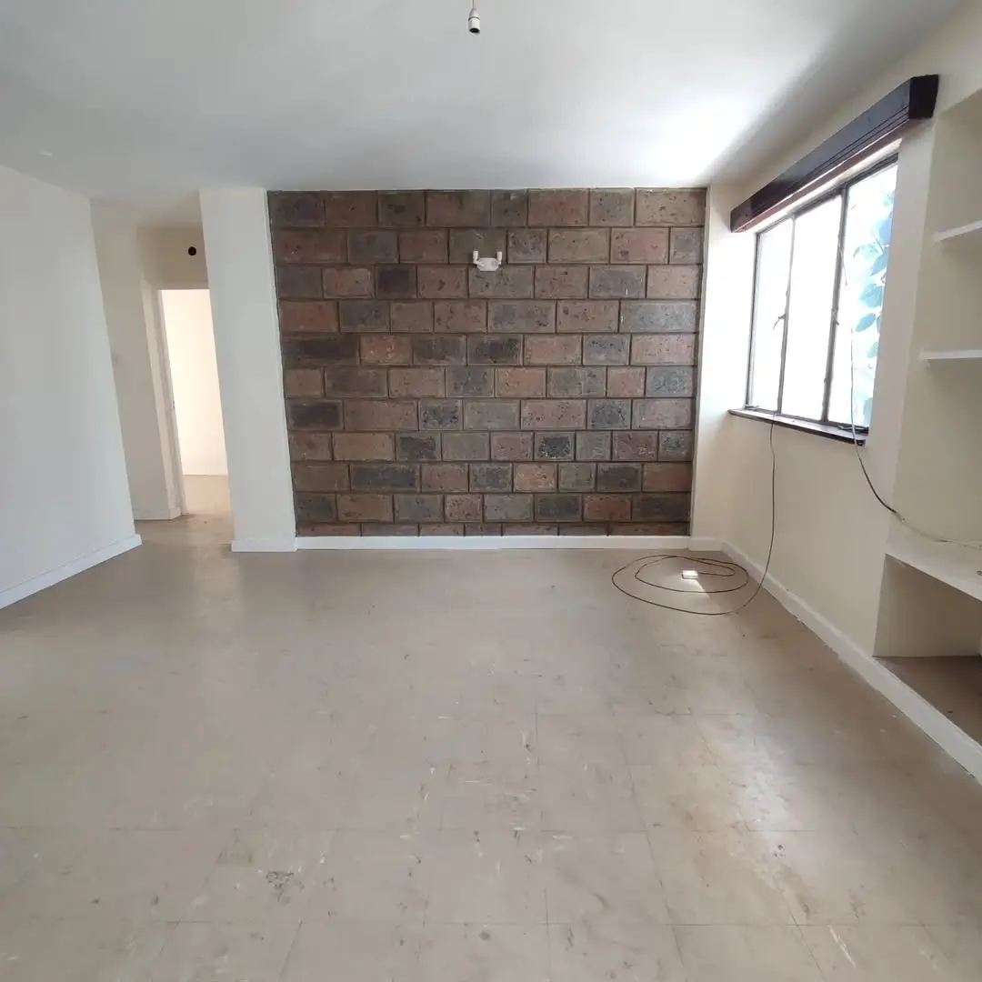 Empty living room with exposed brick wall and natural light
