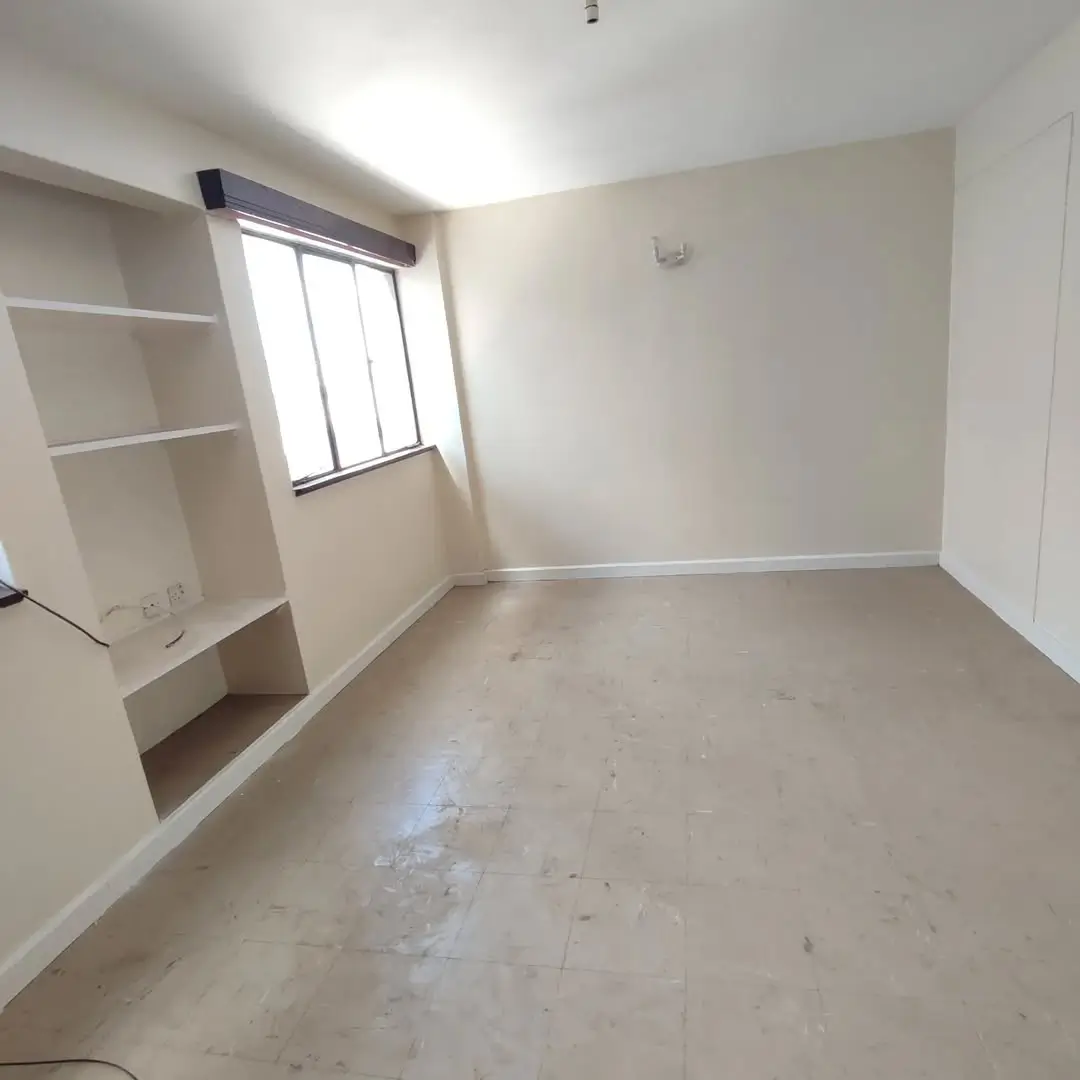 Minimalist bedroom with built-in shelving and window