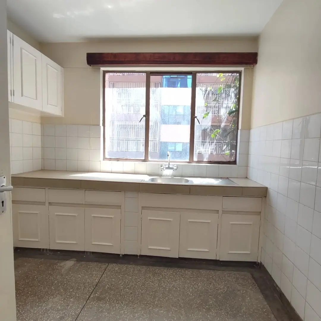 Compact kitchen with cream cabinetry and tiled backsplash