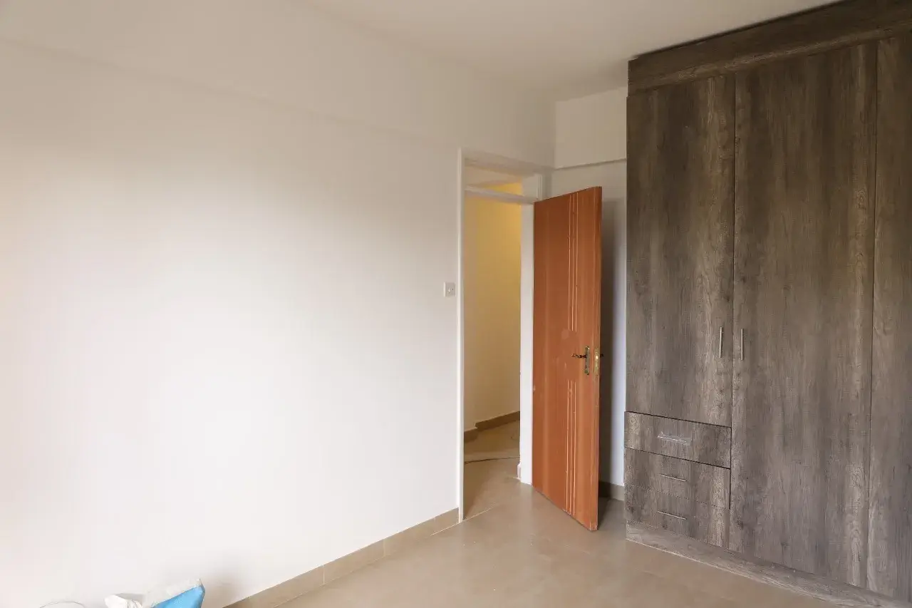 Unfurnished bedroom with built-in wardrobe and open doorway