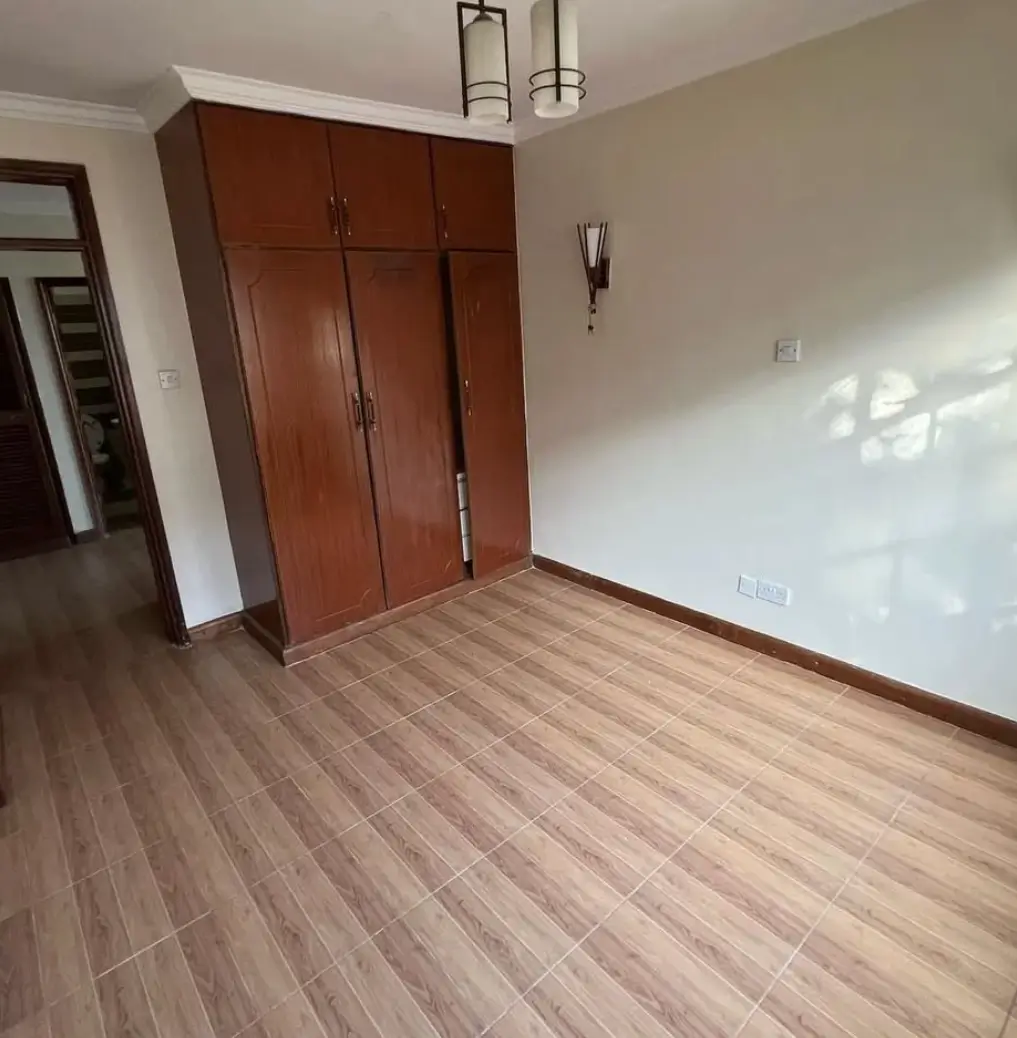 Spacious bedroom with wooden wardrobe and laminate flooring
