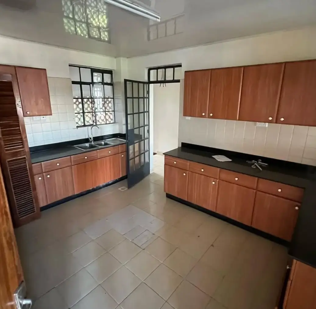 Spacious kitchen with wooden cabinetry and black countertops