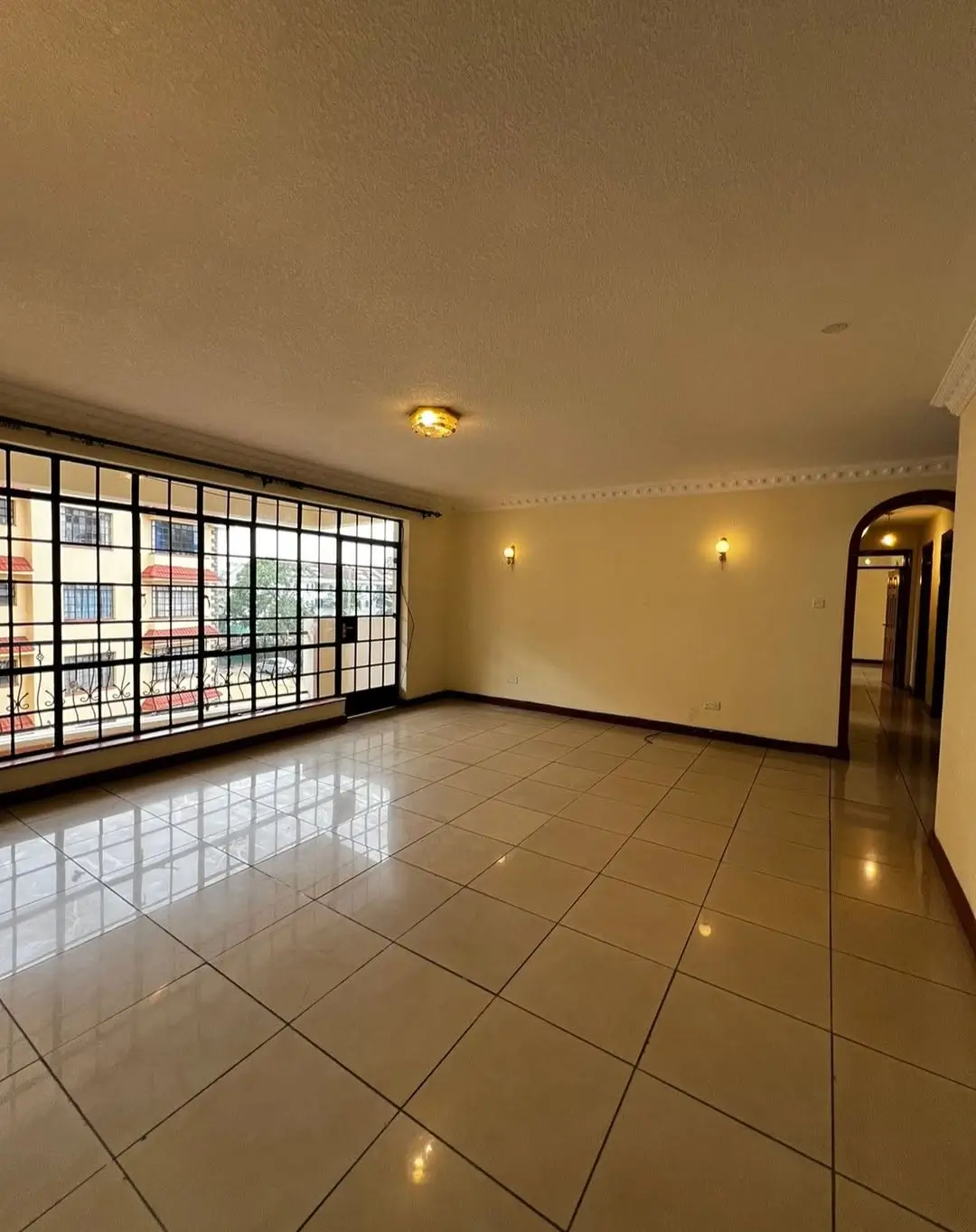 Spacious living room with polished tile flooring and natural light