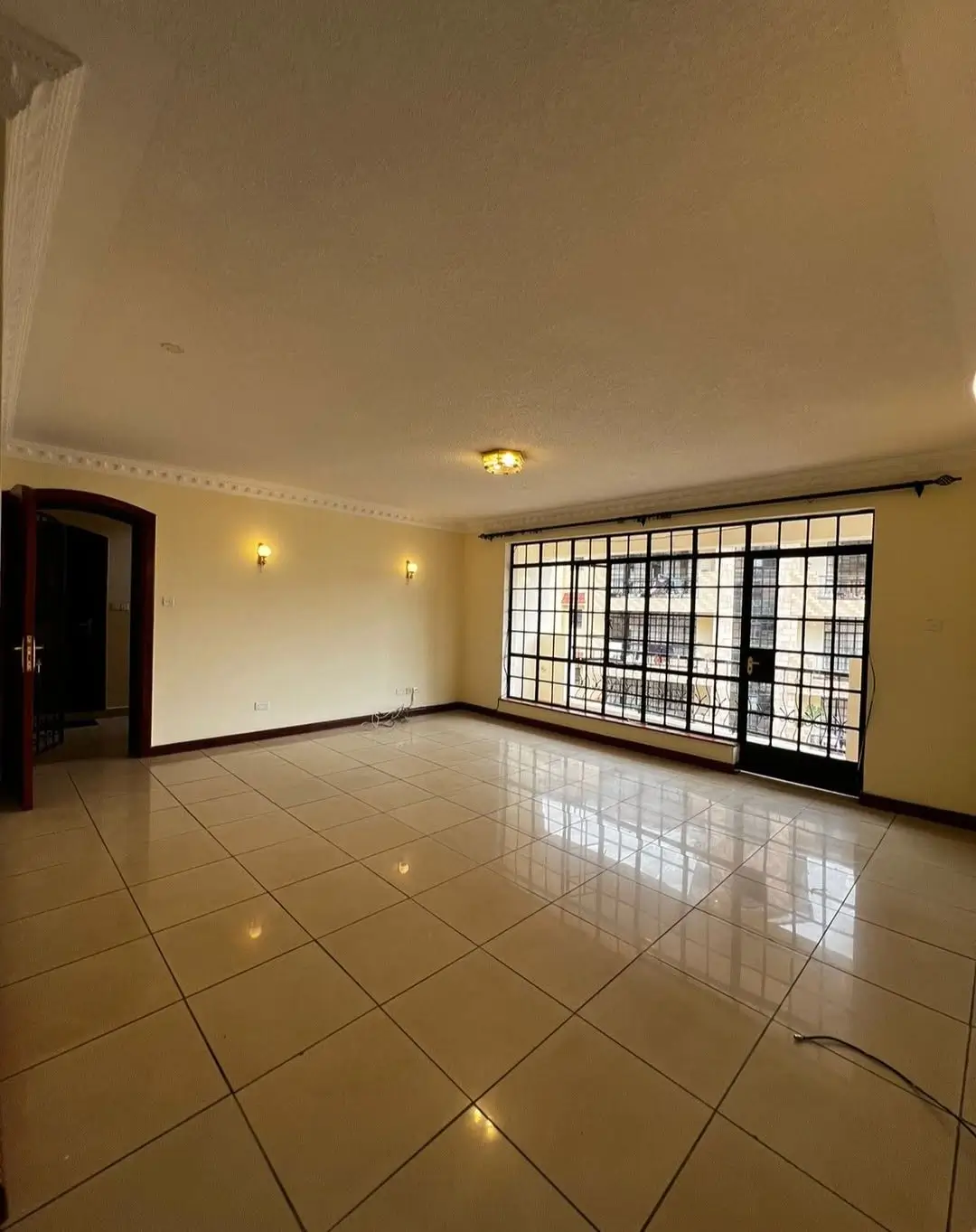 Spacious living room with polished tile flooring and natural light