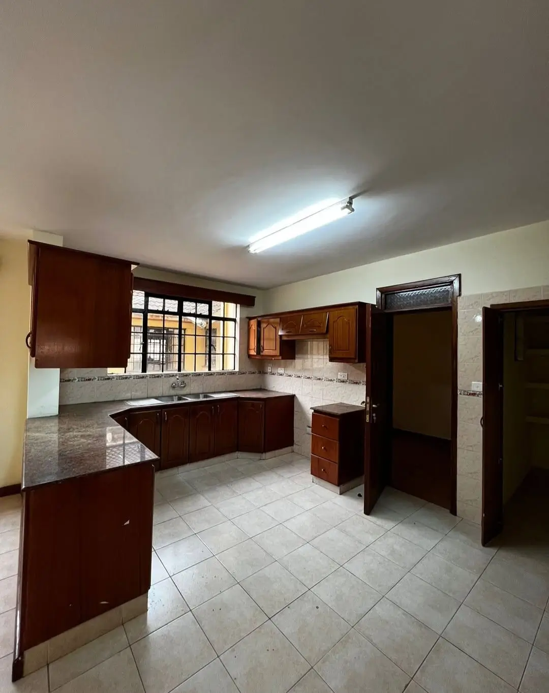 Spacious kitchen with dark wood cabinetry and tile flooring