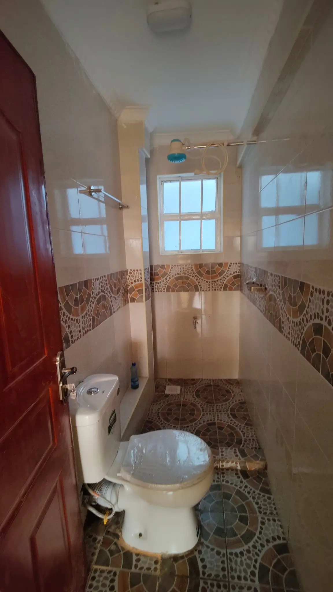 Compact bathroom with toilet, sink, and shower enclosure