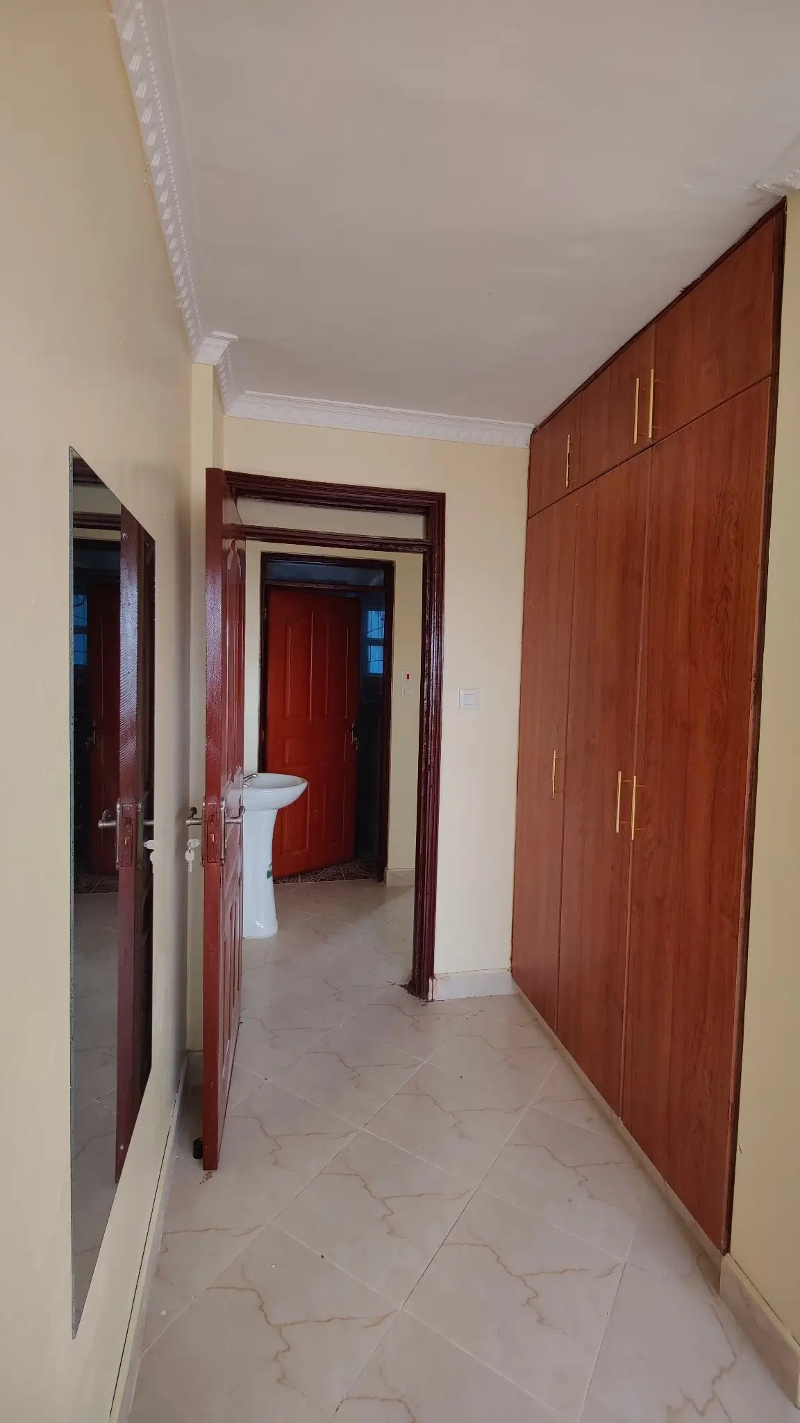 Interior hallway with wooden doors and white walls