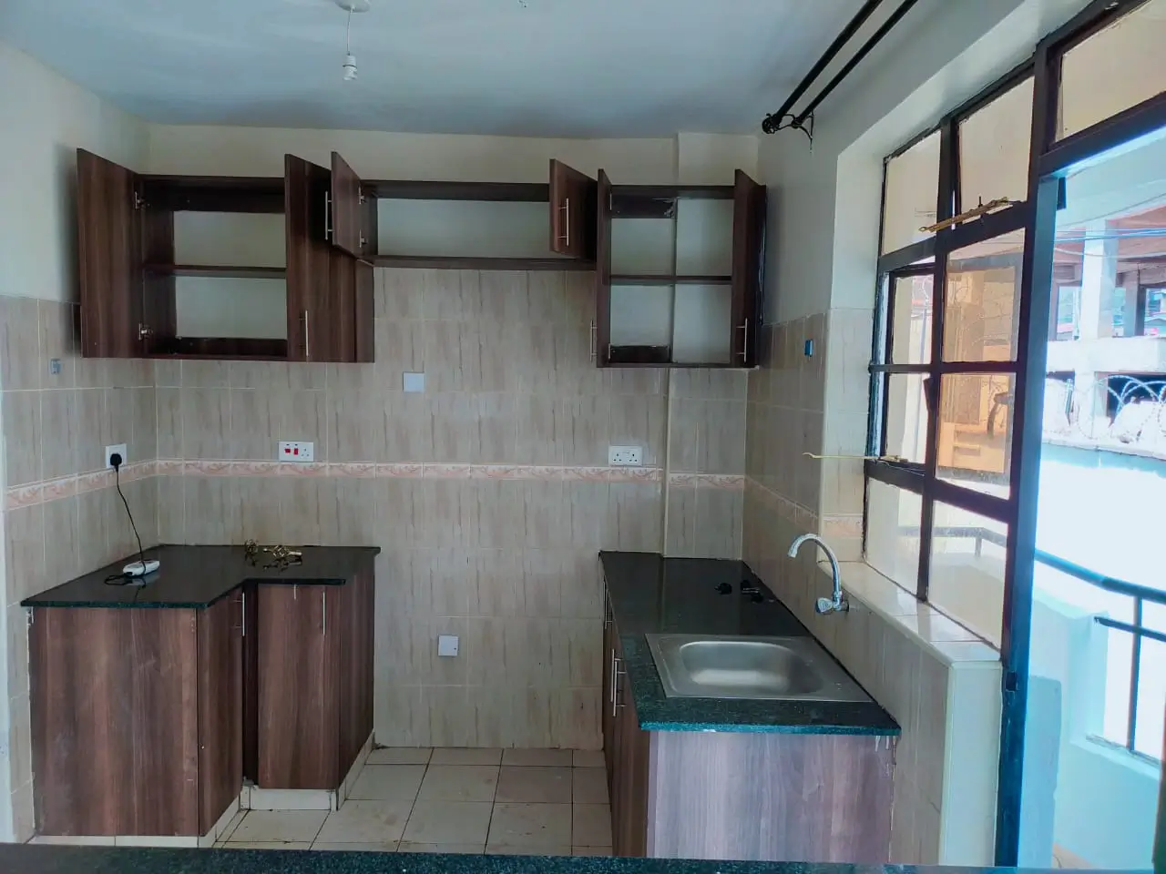 Modern kitchen with dark wood cabinets and stainless steel sink
