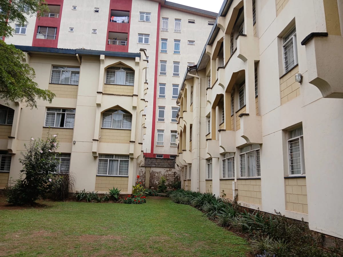 Multi-story residential buildings with manicured compound lawn