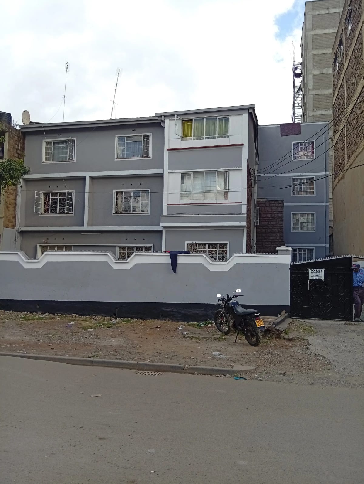 Multi-story residential building facade with gray finish and windows