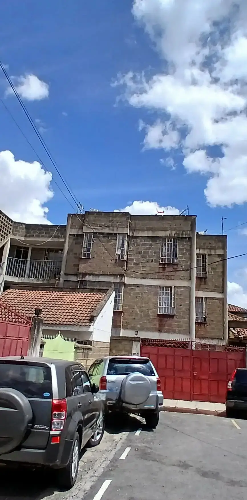 Multi-story residential building facade with street parking