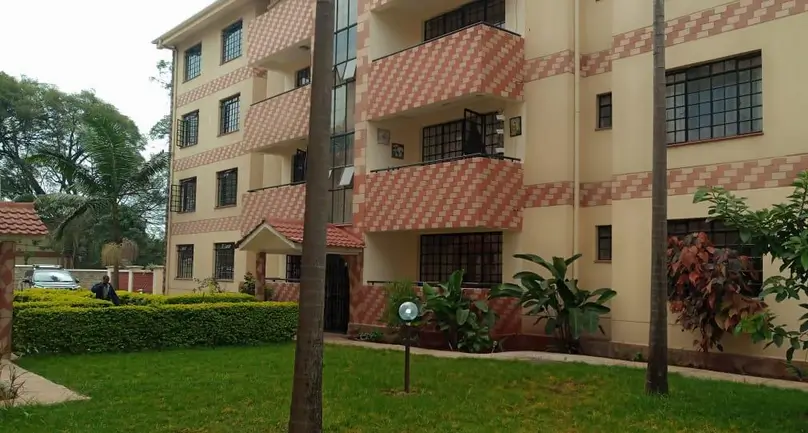 Multi-story residential building with manicured grounds and landscaping