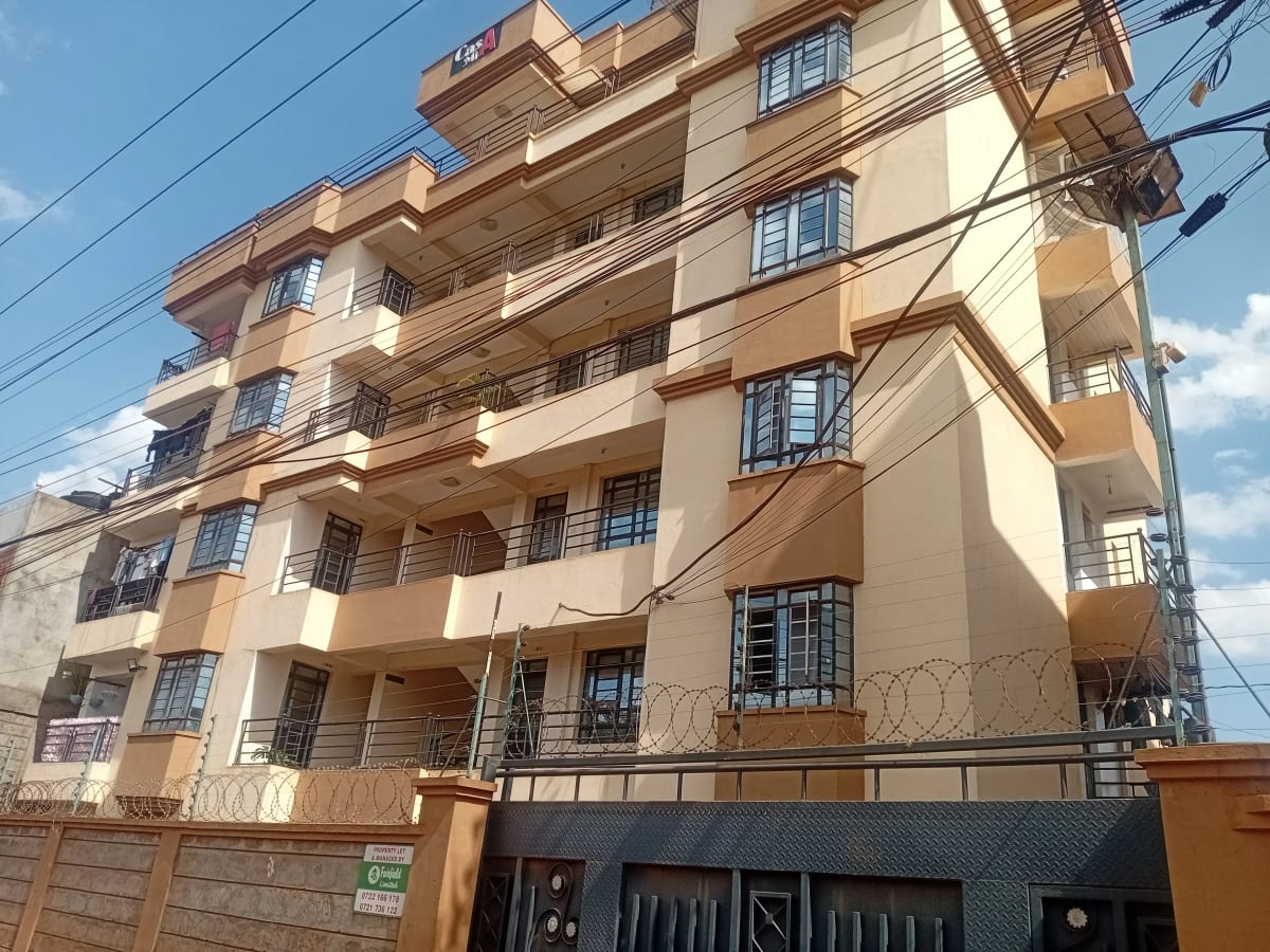 Multi-story residential building facade with balconies and gate