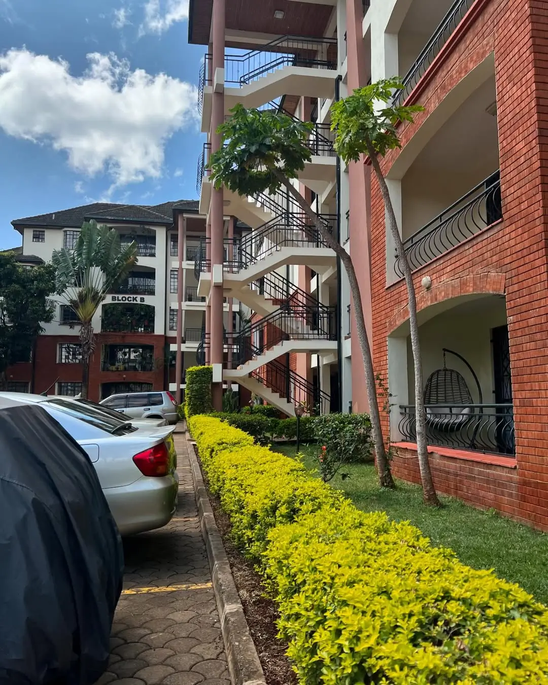 Multi-story residential building with manicured yellow flower landscaping