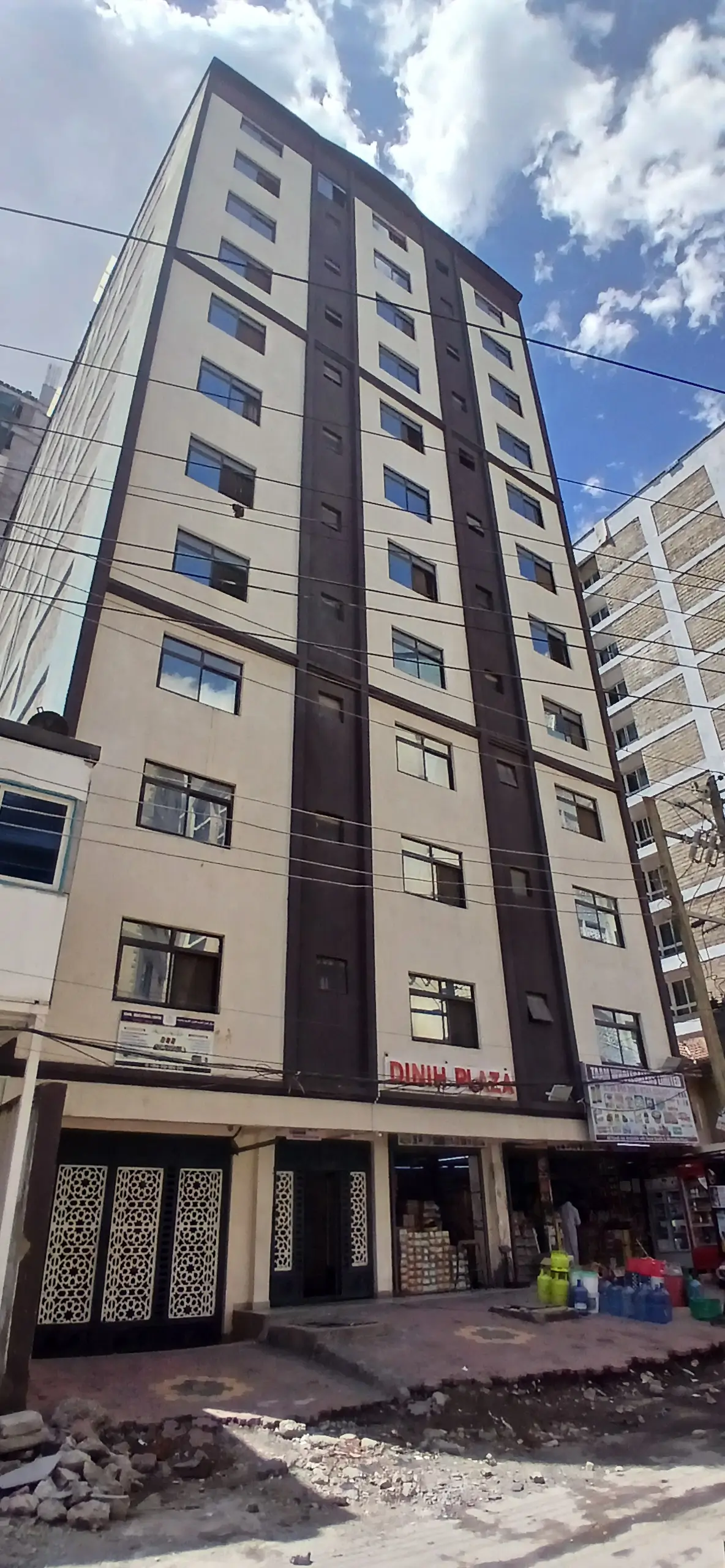 Modern multi-story residential building facade with ground-level shops