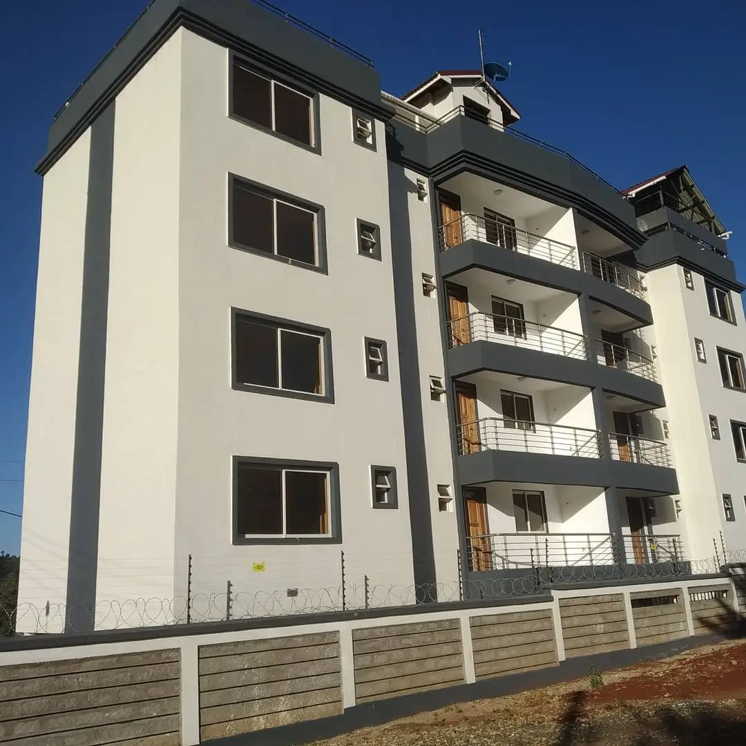 Modern multi-story apartment building with balconies and fence
