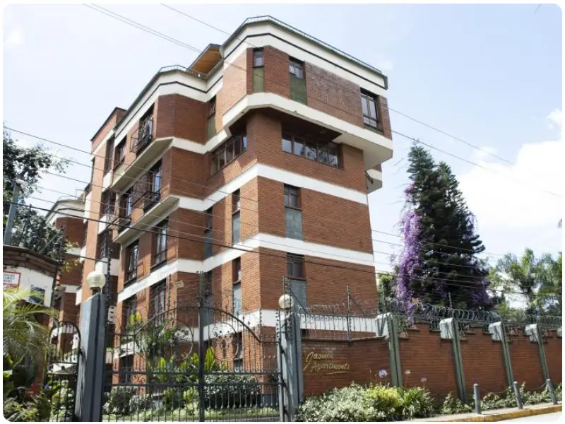 Multi-story brick residential building with manicured compound