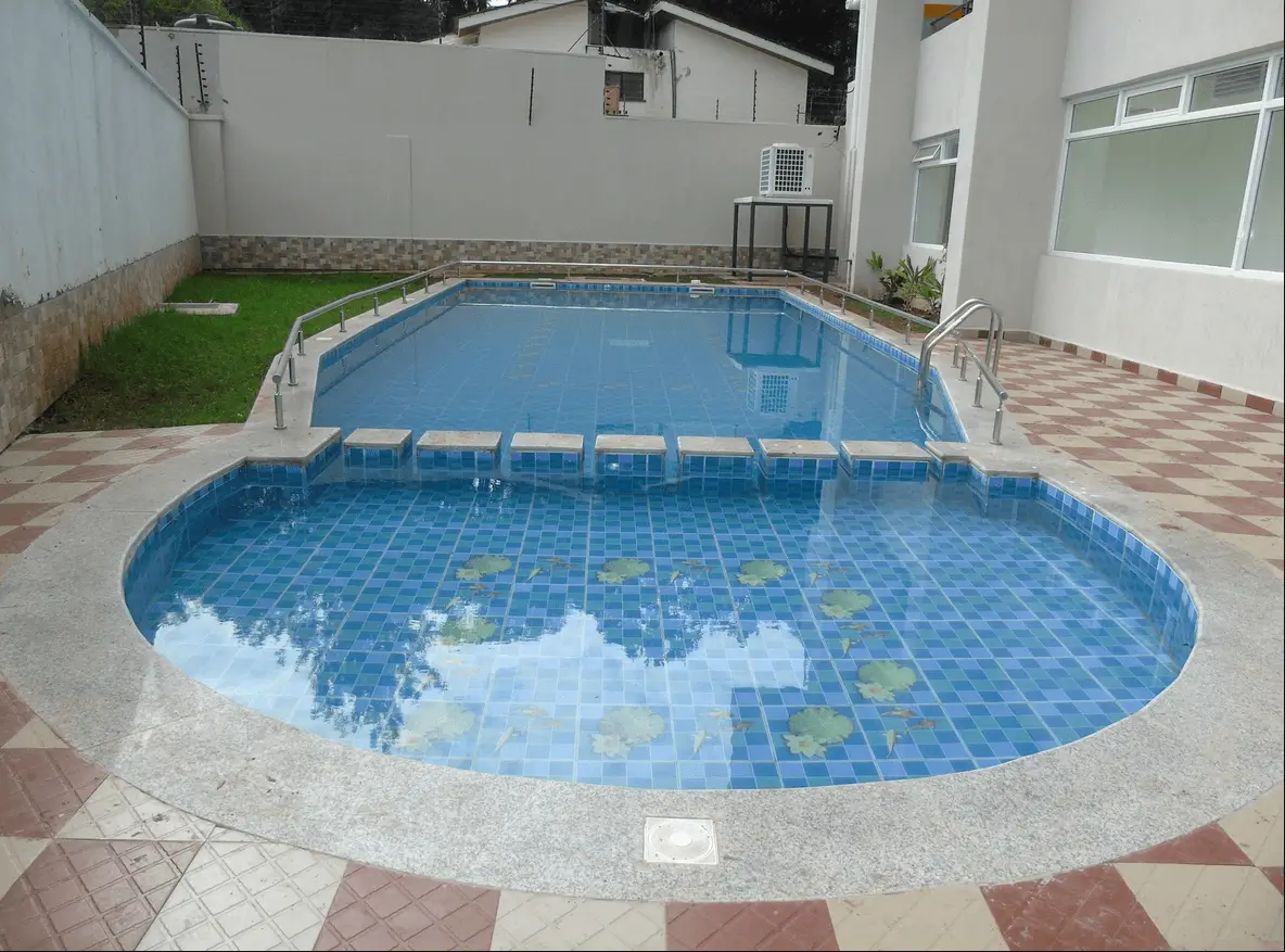 Compound with two swimming pools and manicured lawn