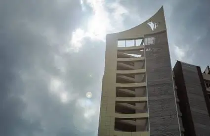 Modern multi-story residential building facade against cloudy sky