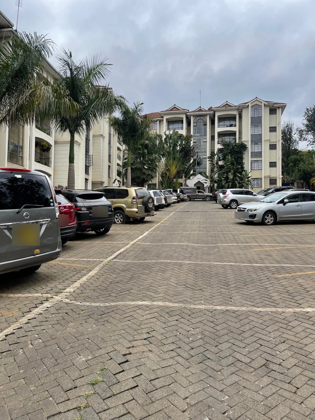 Multi-level residential building with paved parking lot and landscaping