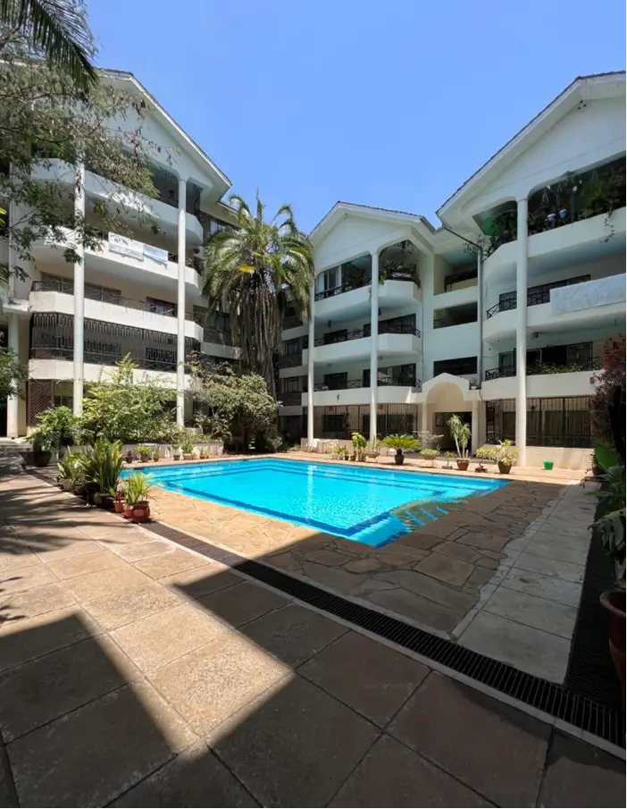 Resort-style swimming pool with surrounding paved deck and loungers