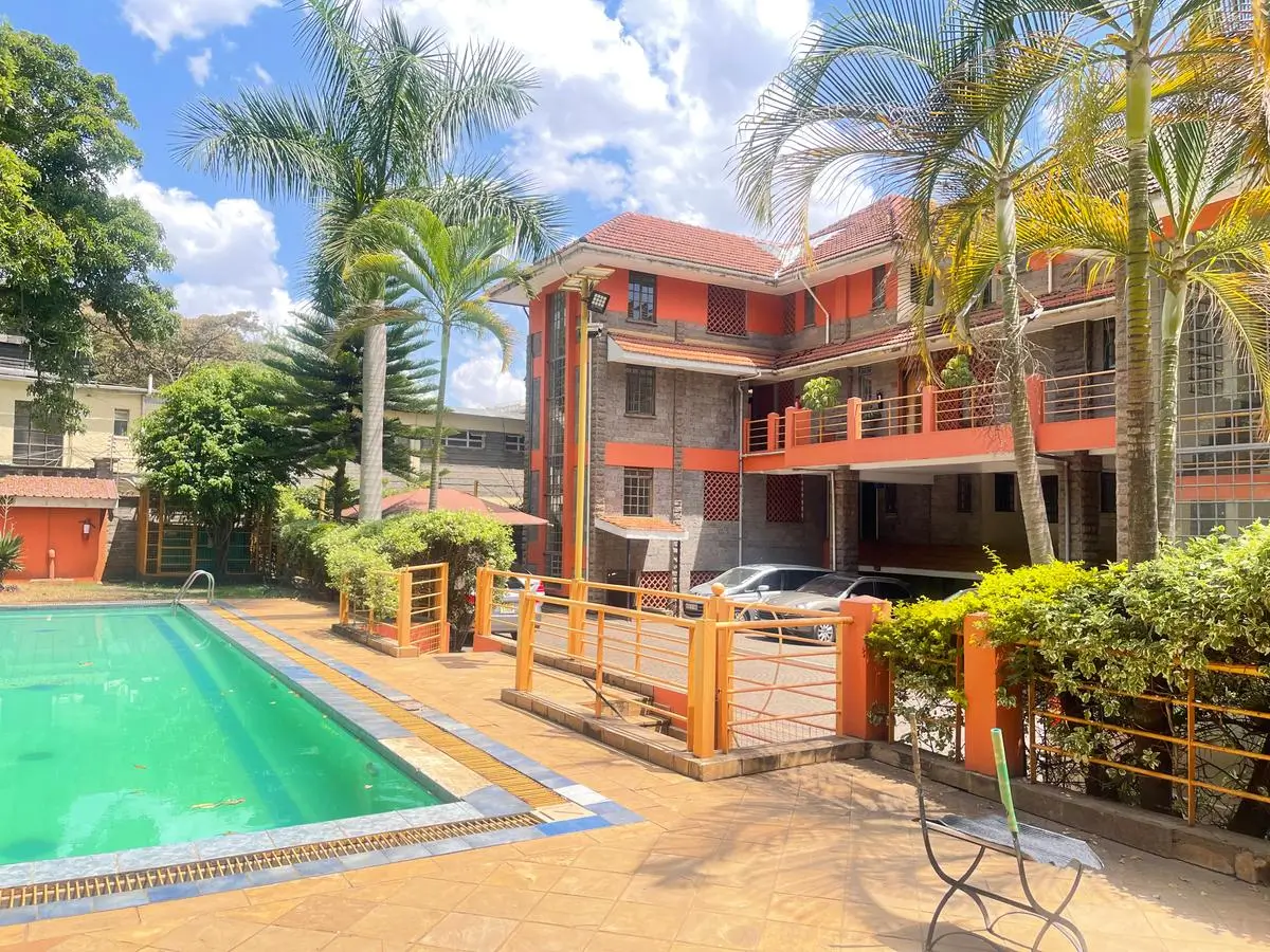 Turquoise swimming pool with orange residential building backdrop