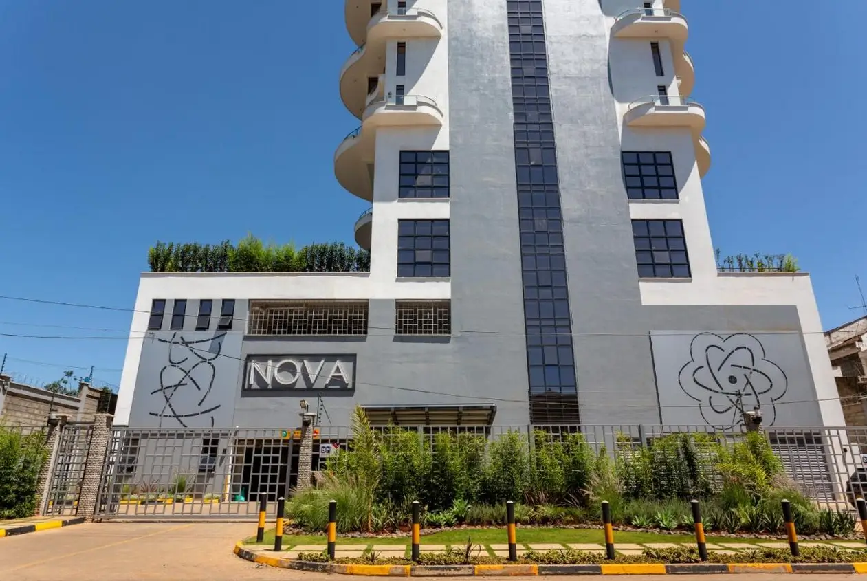 Modern multi-story building facade with curved balconies and landscaping
