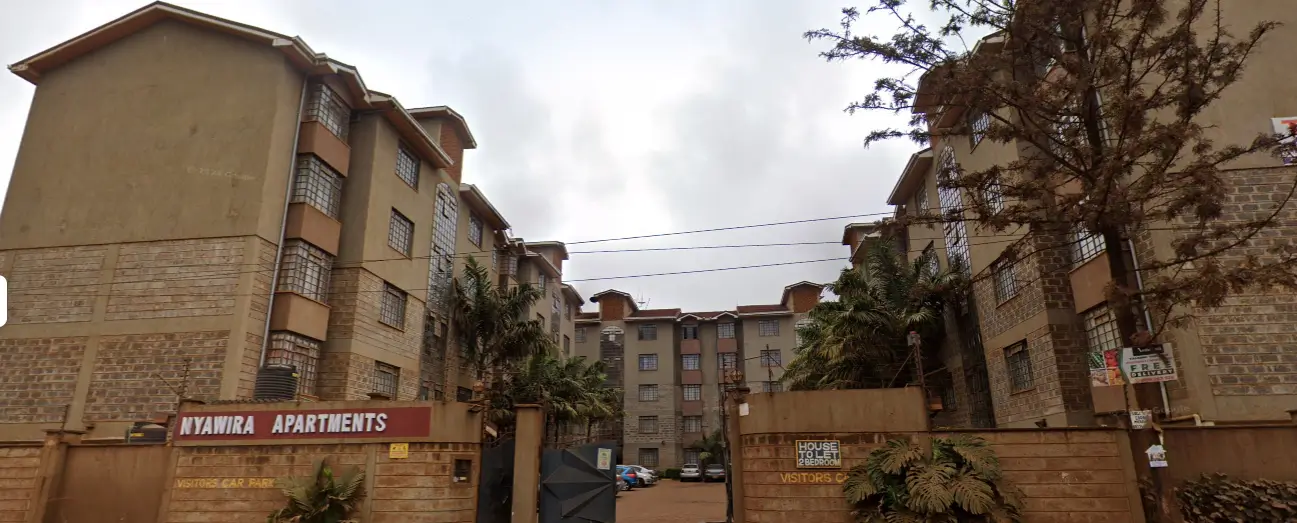 Multi-story residential apartment complex with brick facade and entrance