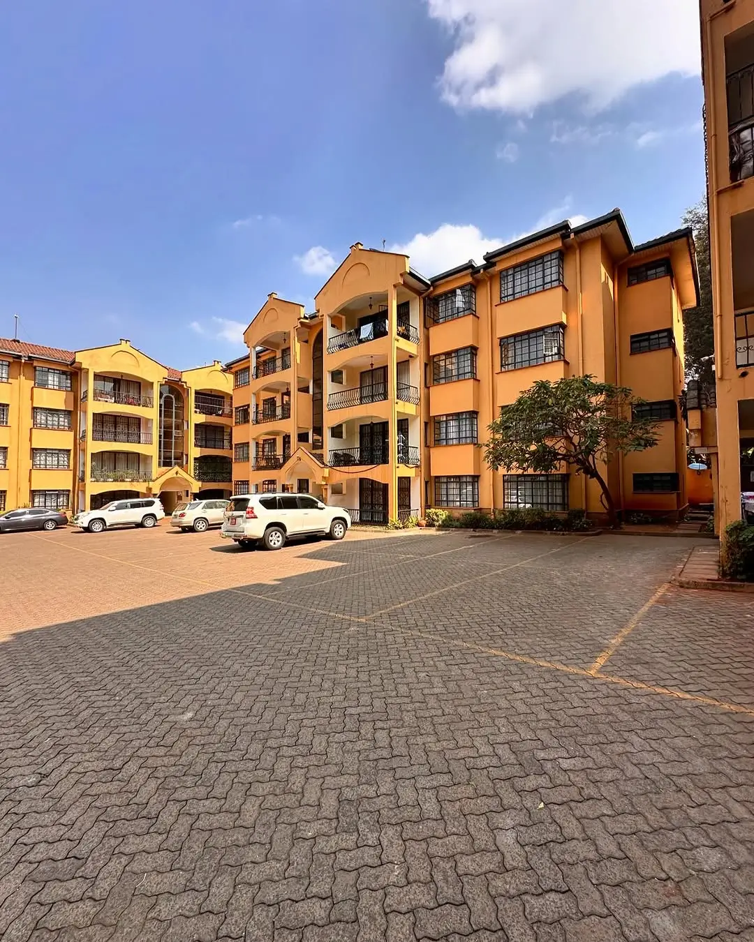 Multi-story residential compound with paved courtyard and parking