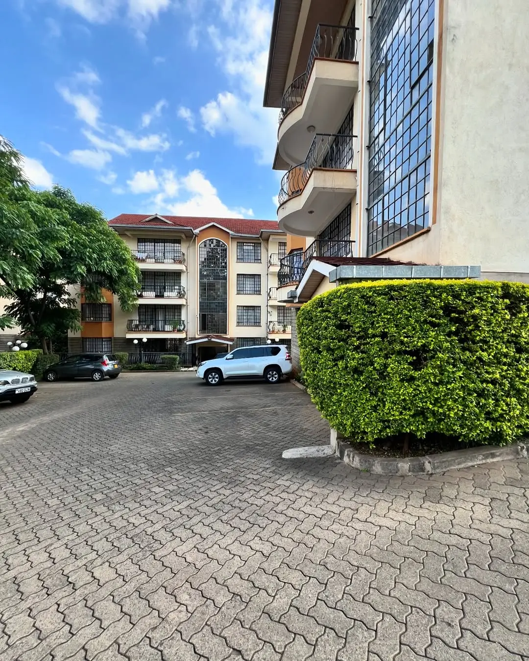 Modern apartment building with paved compound and parking area