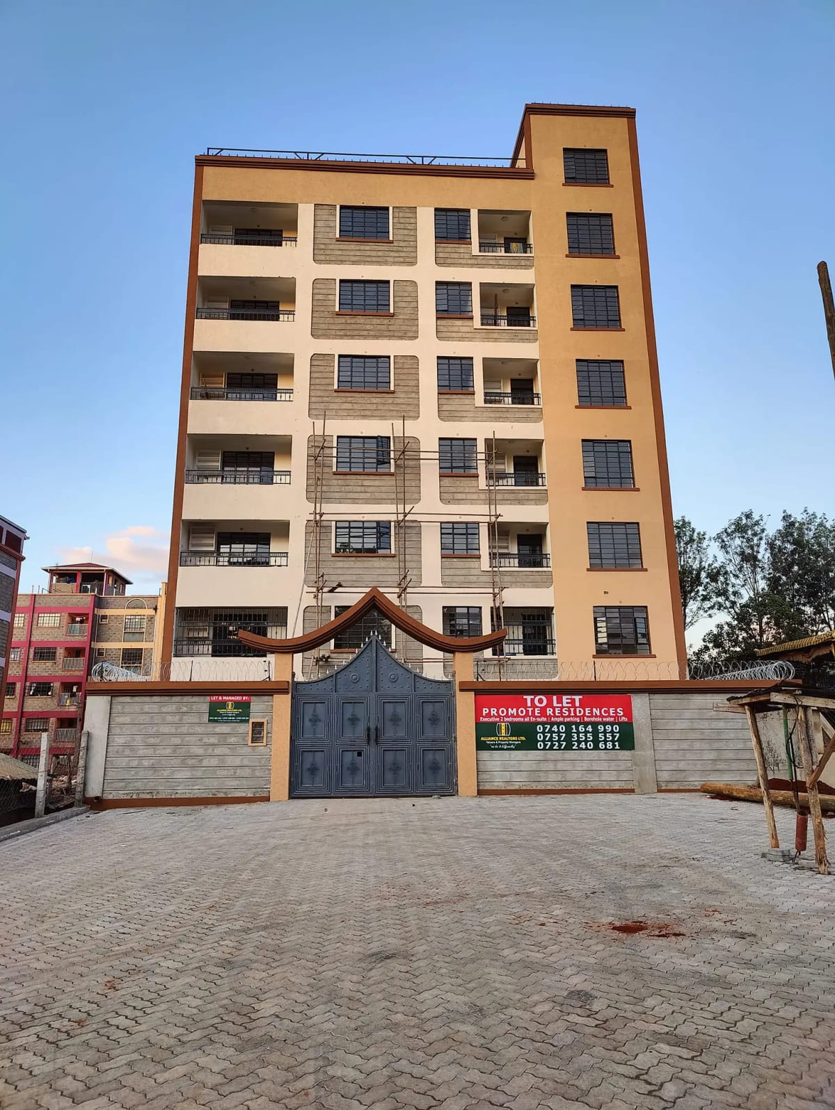 Multi-story residential building facade with blue entrance gate