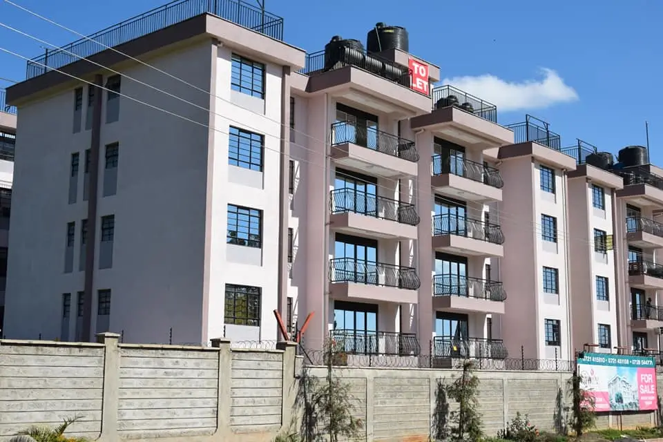 Modern multi-story residential building with balconies and fence