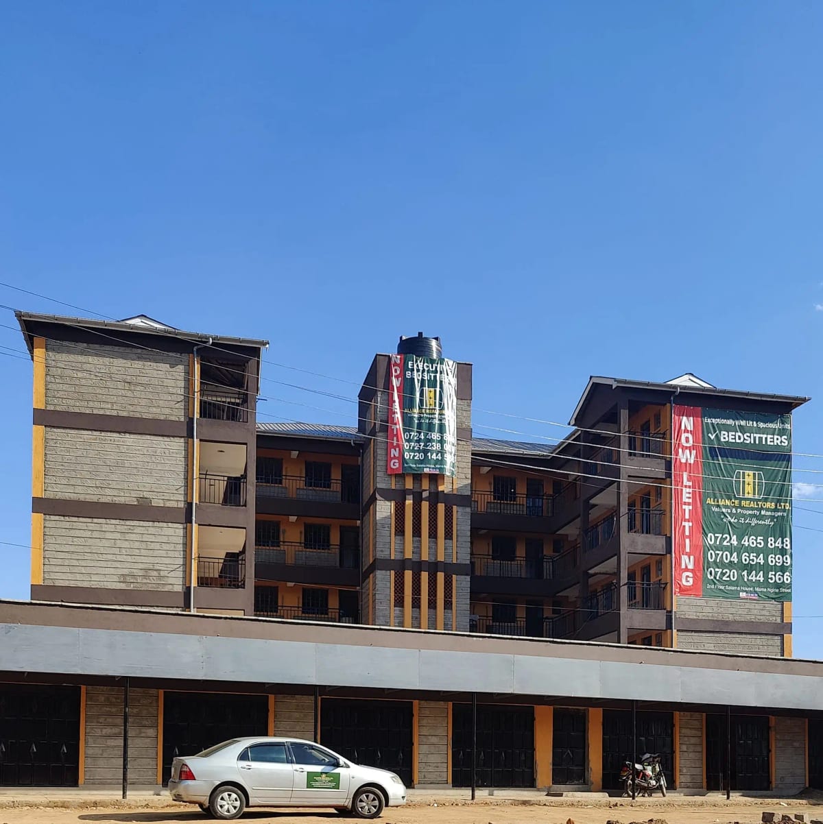 Multi-story residential building facade with ground-floor parking