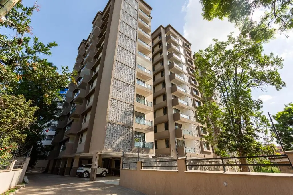Modern multi-story residential building with manicured grounds