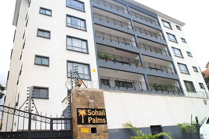 Modern residential building facade with multiple balconies and signage