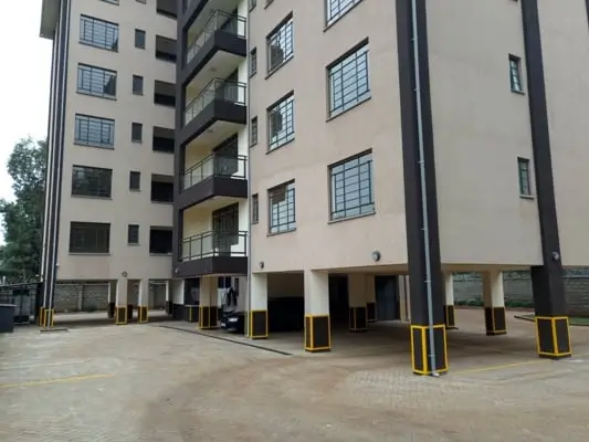 Modern apartment building facade with ground-level parking bays