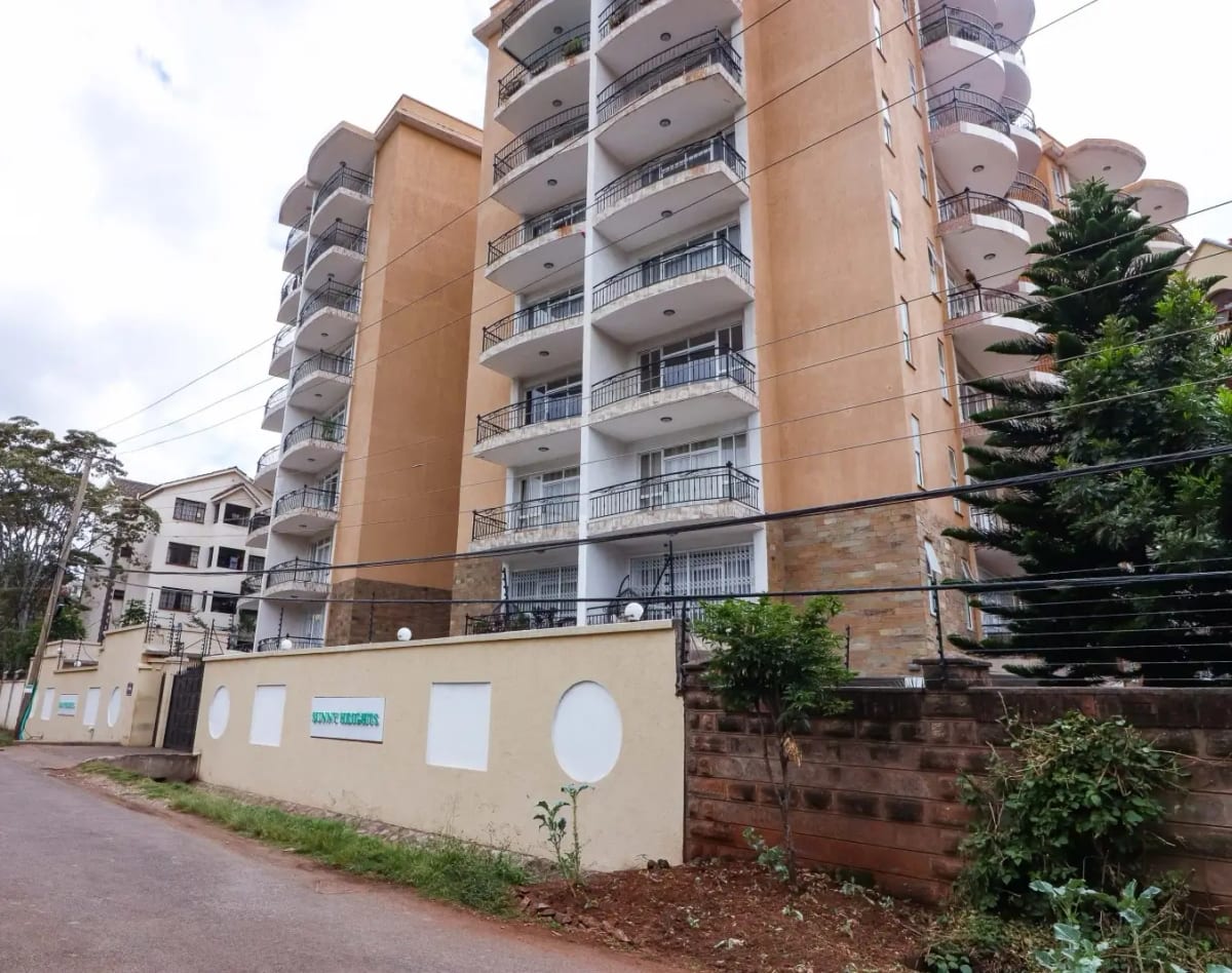 Multi-story residential building with balconies and perimeter wall