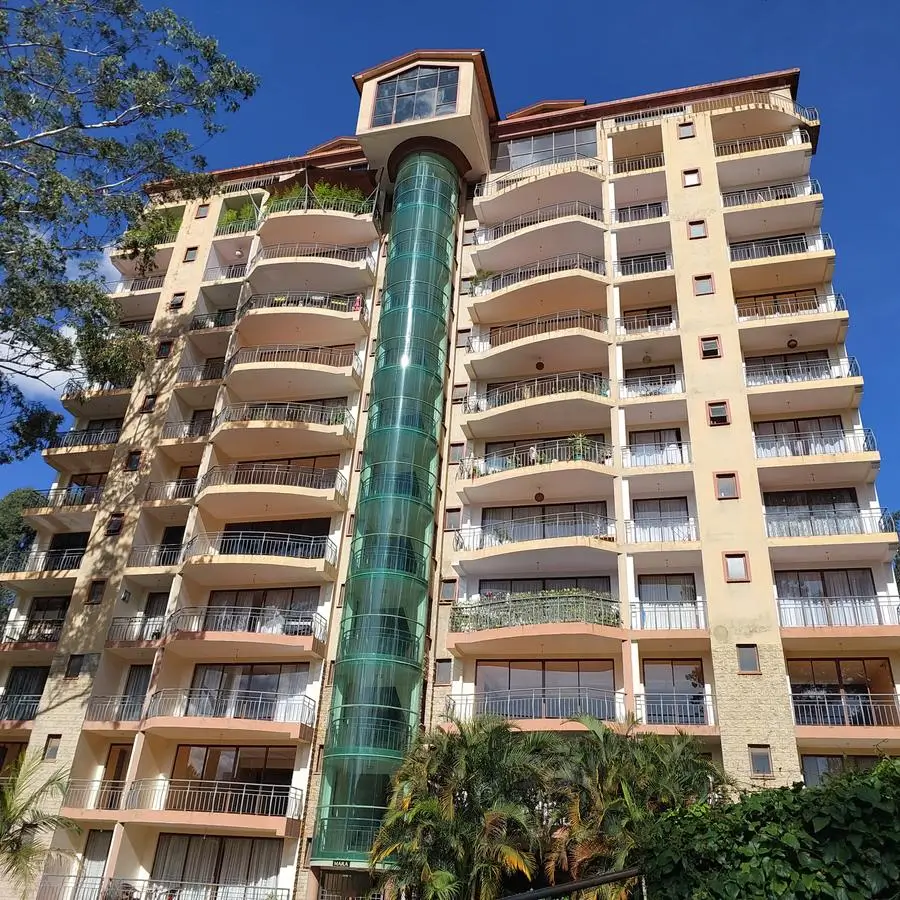 Multi-story residential building facade with balconies and green lift shaft